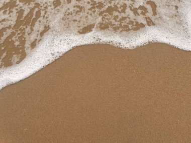 Kumsalın ve beyaz köpük dalgalarının arka planı