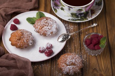 Ahududu ve tabloda çay çaydanlık ile pudra şekeri ile kek