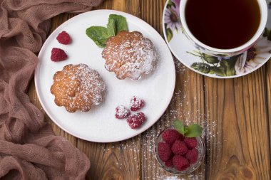 Ahududu ve tabloda çay çaydanlık ile pudra şekeri ile Capcake.