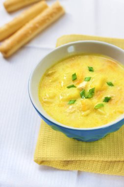 Tavuk, patates ve zerdeçal bir arka plan üzerinde grisini ile peynir çorbası