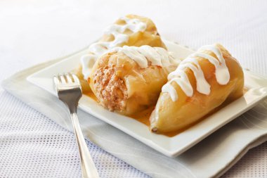 Et ve beyaz bir kare tabak pilav ile doldurulmuş biber