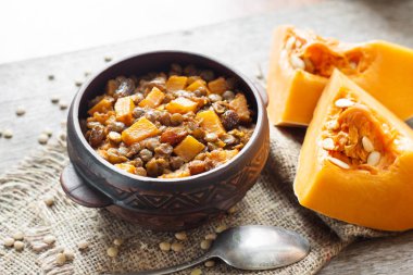 Ev yapımı baharatlı köri yeşil mercimek, kabak ve rustik seramik kase kuru üzüm