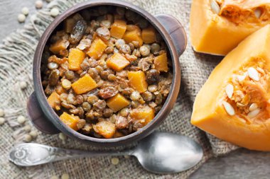 Ev yapımı baharatlı köri yeşil mercimek, kabak ve rustik seramik kase kuru üzüm