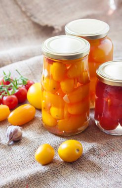 Metal kapak ile kapalı ev yapımı kırmızı ve sarı turşusu domates, cam kavanoz