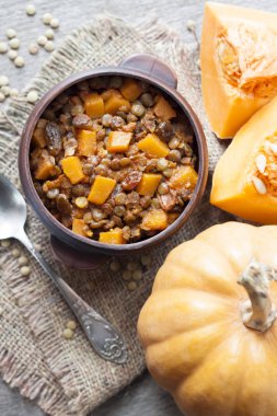 Ev yapımı baharatlı köri yeşil mercimek, kabak ve rustik seramik kase kuru üzüm