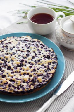 Ev yapımı kek, krepteki mavi plaka ve bir fincan çay içinde belgili tanımlık geçmiş