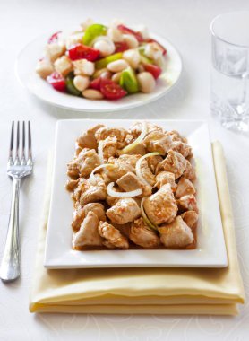 Türkiye güveç domates hardal sos soğan kare plaka ve arka planda renkli domates salatası ile