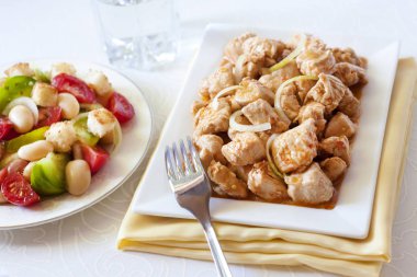 Türkiye güveç domates hardal sos soğan kare plaka ve arka planda renkli domates salatası ile