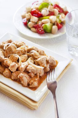 Türkiye güveç domates hardal sos soğan kare plaka ve arka planda renkli domates salatası ile