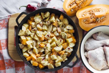 One-pot yemek - tavuk uyluk ve bacaklar patates ve kabak ile dökme demir tavada pişmiş