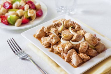 Türkiye güveç domates hardal sos soğan kare plaka ve arka planda renkli domates salatası ile