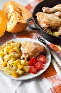 One-pot yemek - tavuk uyluk ve bacaklar patates ve dökme demir tavada pişmiş kabak ile