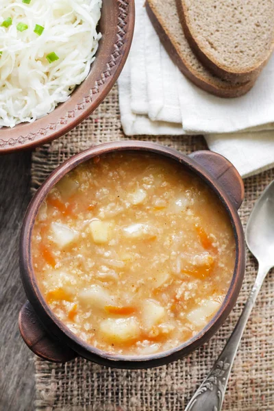 Kapustnyak - traditional ukrainian winter soup with sauerkraut, millet and meat in rustic bowl — Stock Image Kapustnyak Traditional Ukrainian Winter Soup Sauerkraut Millet Meat Rustic Bowl Royalty Free Stock Images