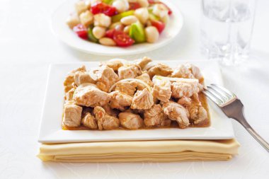 Türkiye güveç domates hardal sos soğan kare plaka ve arka planda renkli domates salatası ile