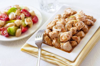 Türkiye güveç domates hardal sos soğan kare plaka ve arka planda renkli domates salatası ile