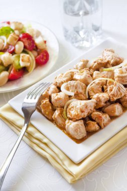 Türkiye güveç domates hardal sos soğan kare plaka ve arka planda renkli domates salatası ile