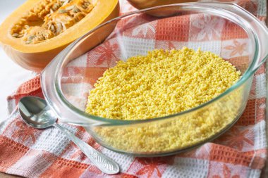 Tatlı süt yulaf lapası kabak ve kuru üzüm ile pişirme sürecinde bir cam tavada ham yıkanmış darı