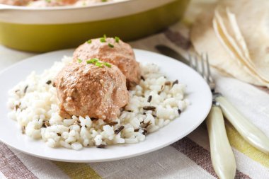 Kremalı Domates soslu beyaz tabakta pilavlı tavuk köfte