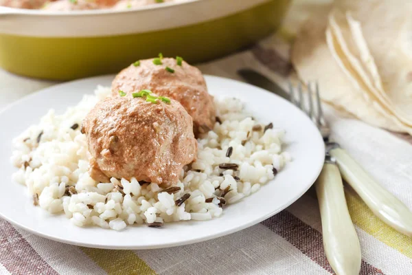 Kremalı Domates soslu beyaz tabakta pilavlı tavuk köfte
