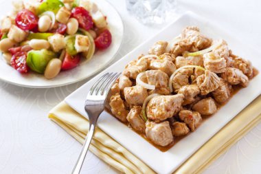 Türkiye güveç domates hardal sos soğan kare plaka ve arka planda renkli domates salatası ile