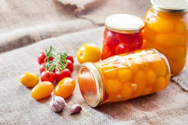 Metal kapak ile kapalı ev yapımı kırmızı ve sarı turşusu domates, cam kavanoz