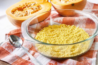 Tatlı süt yulaf lapası kabak ve kuru üzüm ile pişirme sürecinde bir cam tavada ham yıkanmış darı