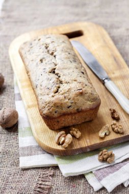 Ceviz ve ahşap tahta üzerinde koyu çikolata muzlu kek