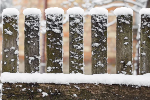 Wooden rural fence covered with snow