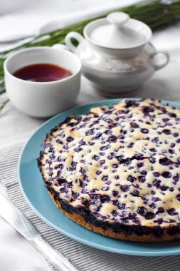 Ev yapımı kek, krepteki mavi plaka ve bir fincan çay içinde belgili tanımlık geçmiş