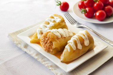 Et ve beyaz bir kare tabak pilav ile doldurulmuş biber