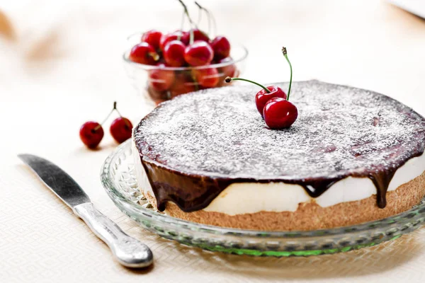 Bird's Milk souffle cake, covered with chocolate glaze and icing and decorated with ripe juicy cherries — Stock Photo, Image