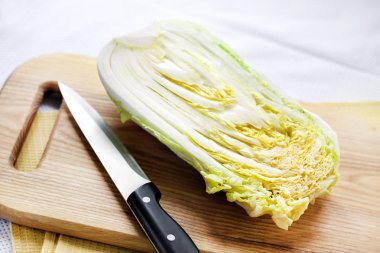 Çin lahanası ahşap kesme tahtası üzerinde yarısı