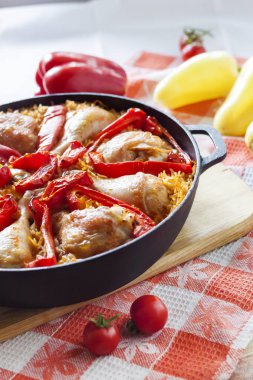 Pişmiş pirinç ve kırmızı biber bir yatak üzerinde Tavuk uyluk ve bacaklar