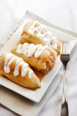 Et ve beyaz bir kare tabak pilav ile doldurulmuş biber