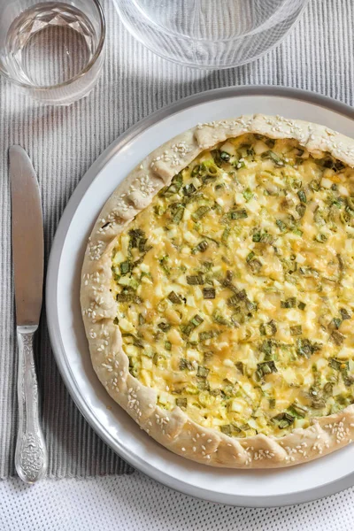 Tart with eggs and green onions on a plate — Stock Photo, Image