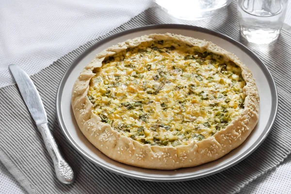 Tart with eggs and green onions on a plate — Stock Photo, Image