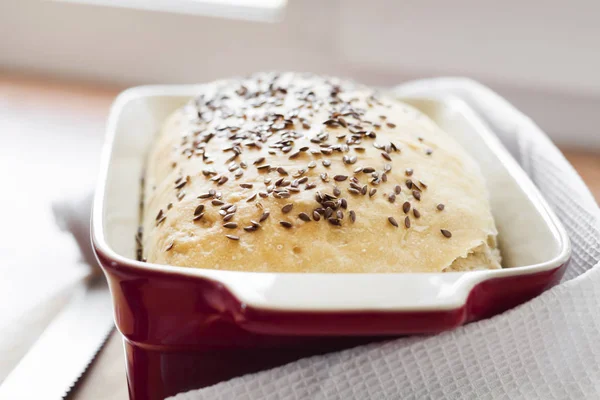 Pan de trigo casero con semillas de lino en bandeja de horno de cerámica —  Fotos de Stock