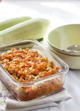 Bir kare cam çanak havuç ve domates ile squash güveç