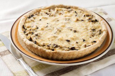 Bir plaka üzerinde mantar ve peynir ile tavuk tart