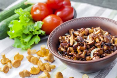 Arka planda salata için taze sebzeler ile rustik kase ve plaka soğan ile Fried chanterelles