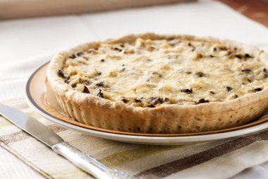 Bir plaka üzerinde mantar ve peynir ile tavuk tart