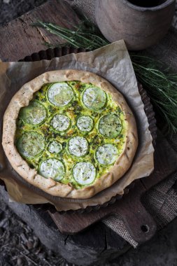 Koyu rustik ahşap tahta arka planda ev yapımı kabak ve keçi peyniri pasta