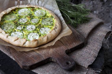 Koyu rustik ahşap tahta arka planda ev yapımı kabak ve keçi peyniri pasta