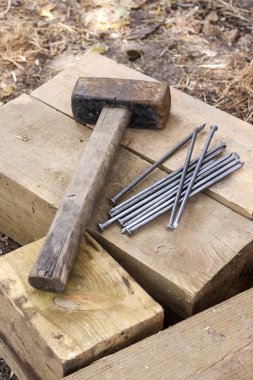 Vintage eski paslı çekiç ve çivi ahşap çubuklar üzerinde yalan
