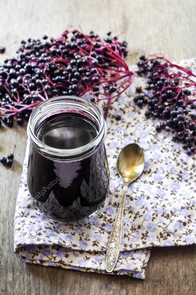 Homemade black elderberry syrup in glass jar 