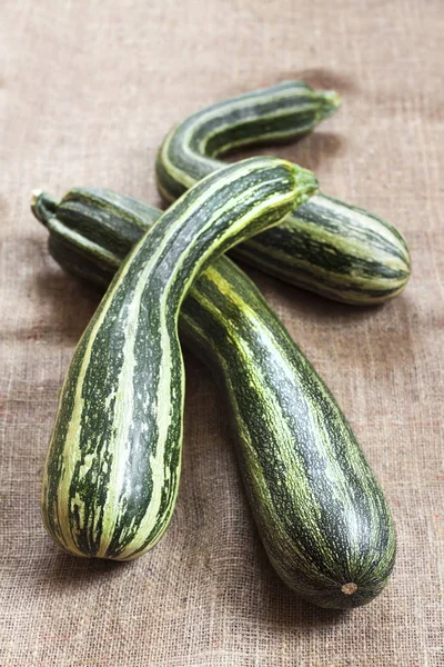 Frische gestreifte Zucchini auf Sacktuch Hintergrund — Stockfoto