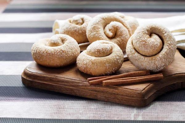 Biscoitos de açúcar de caracol com canela na placa de madeira — Fotografia de Stock