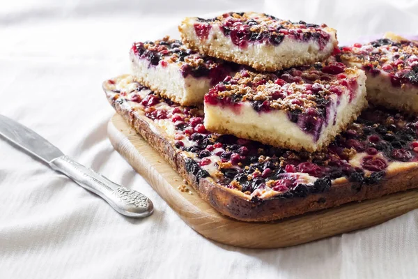 Крупный план ягодного пирога с творогом, нарезанным на квадратные ломтики — стоковое фото