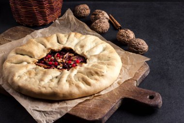 Elmalı, böğürtlenli ve fındıklı ev yapımı galette turtası. Kırsal arka planda taze inek çileğiyle süslenmiş.
