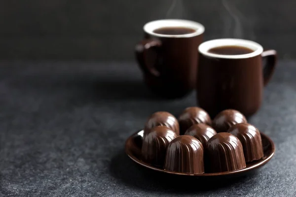 Permen Coklat Piring Dan Dua Cangkir Kopi Panas Latar Belakang — Stok Foto